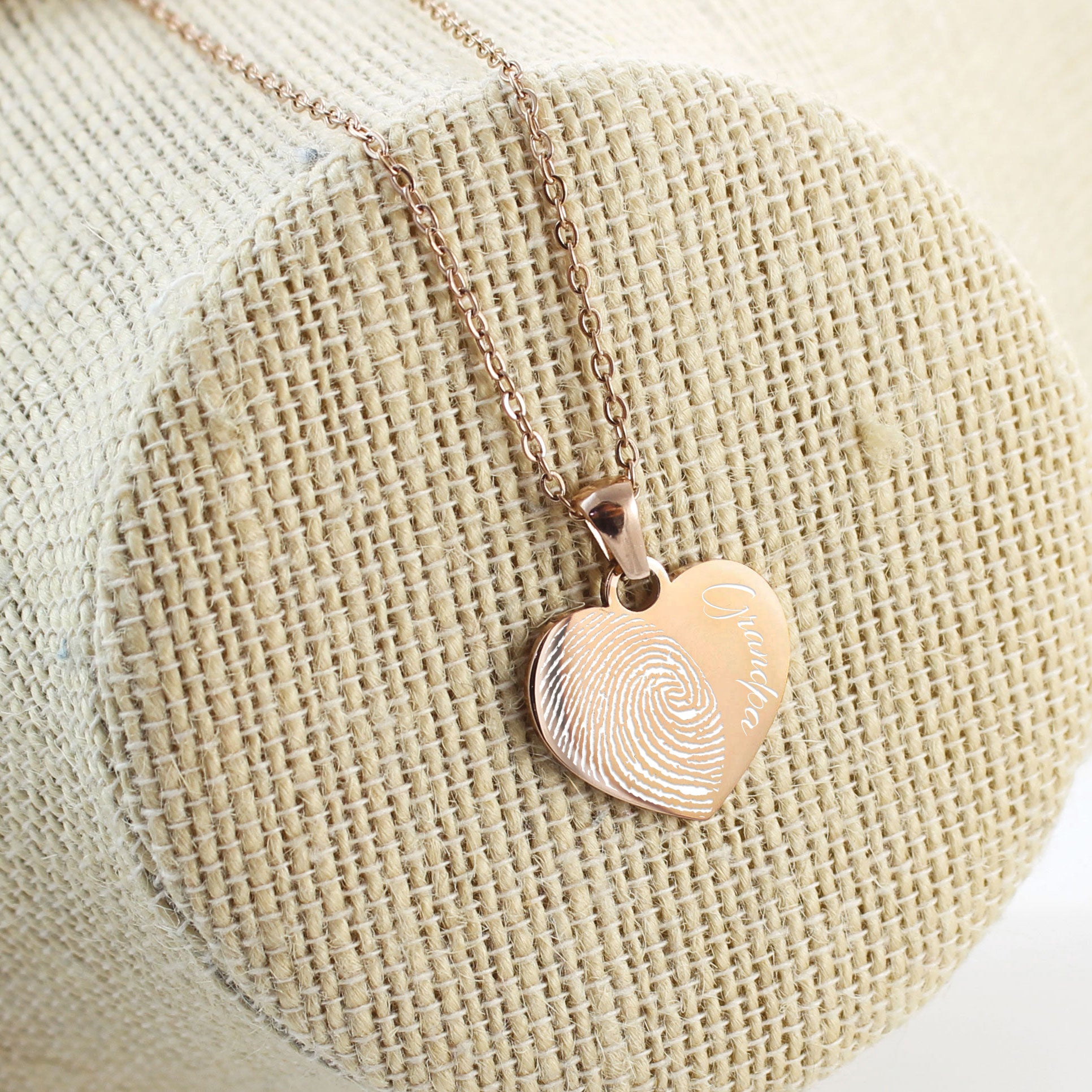"Each pendant features a detailed half-heart fingerprint engraving paired with personalized names like 'Grandpa,' 'Love Dad,' and 'Love Papa' in an elegant script font."