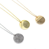 Three round disc necklaces in silver, gold, and rose gold finishes. Each pendant features a high-detail fingerprint engraving. The gold and rose gold discs also include custom name engravings—'Mom' and 'Grandma'—in a delicate cursive script.