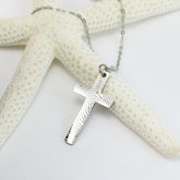 Silver cross pendant necklace on a starfish with a white background