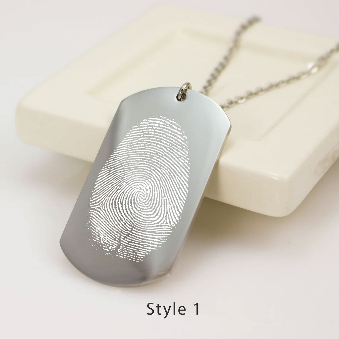 "Custom fingerprint dog tag necklace in a brushed silver finish. A high-definition actual thumbprint is laser-engraved onto a vertical rectangular pendant with curved edges, labeled as Style 1."