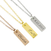 Three vertical bar necklaces in rose gold, gold, and silver. The rose gold bar is engraved with the name 'Olivia,' the gold bar features 'Eva' with a small heart, and the silver bar displays the date '8.12.2023.'