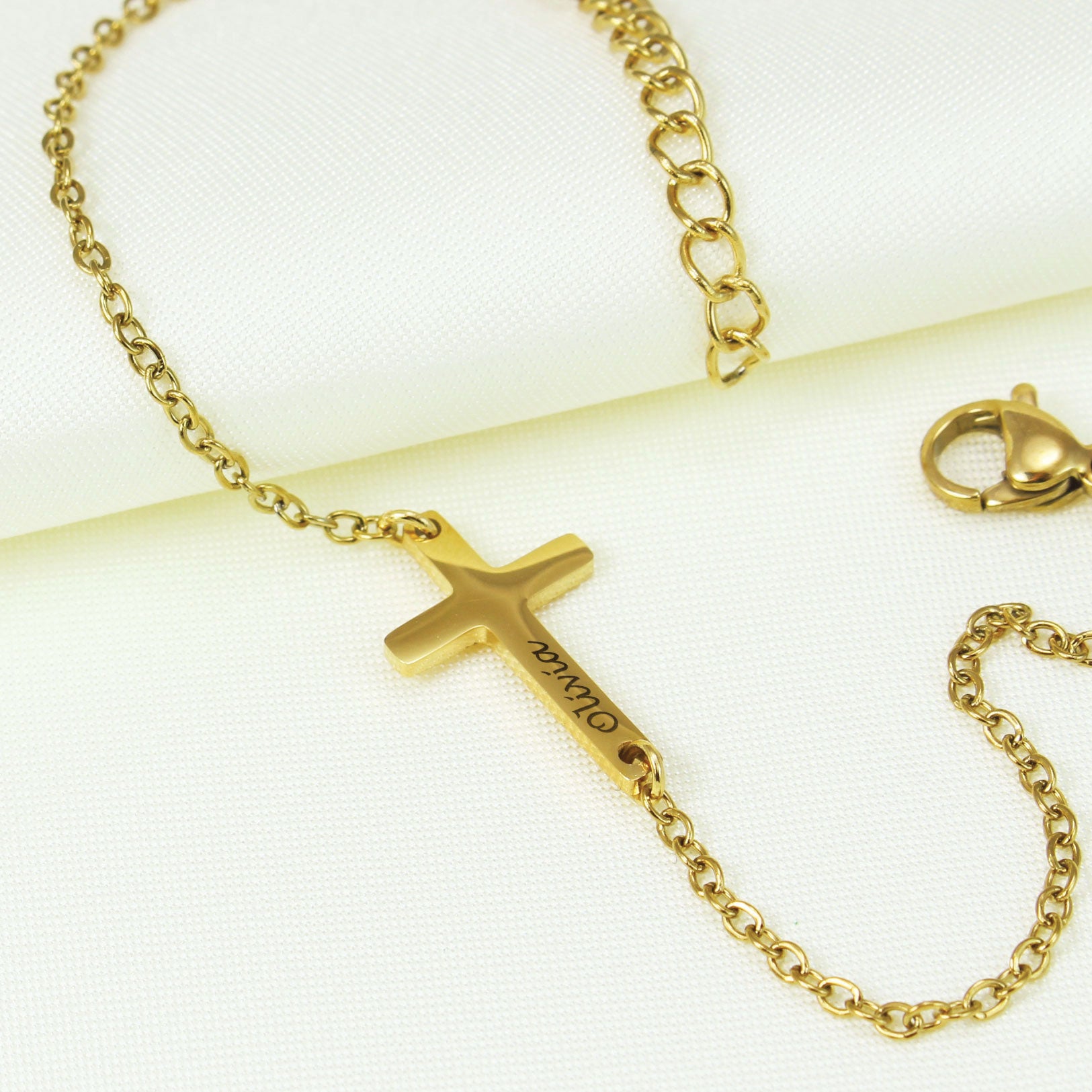 Gold necklace with a cross pendant on a white background