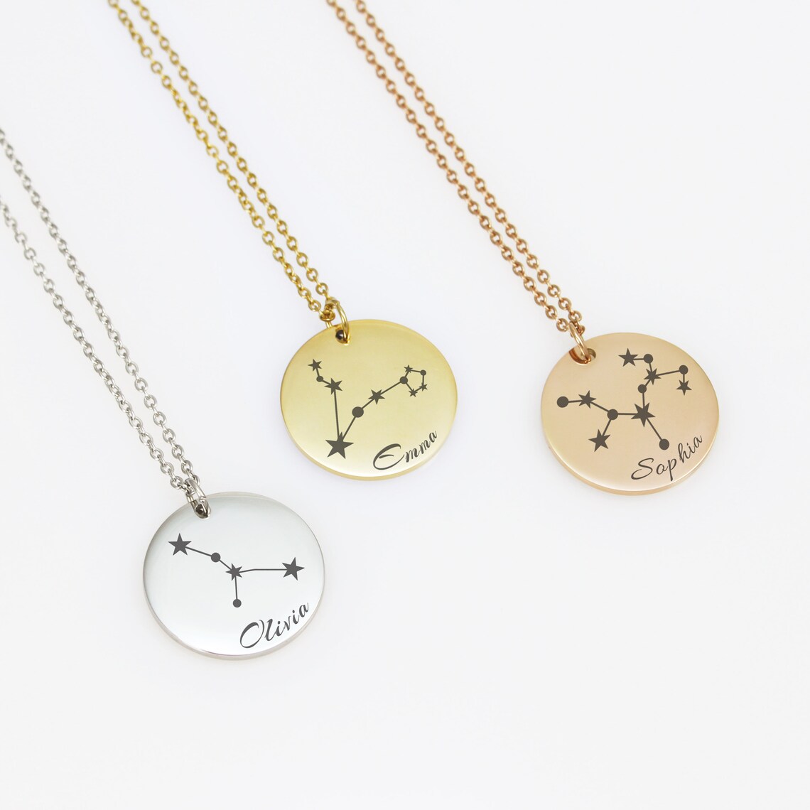 Each piece features a delicate, minimalist engraving of a zodiac constellation paired with a custom name in an elegant script font. 