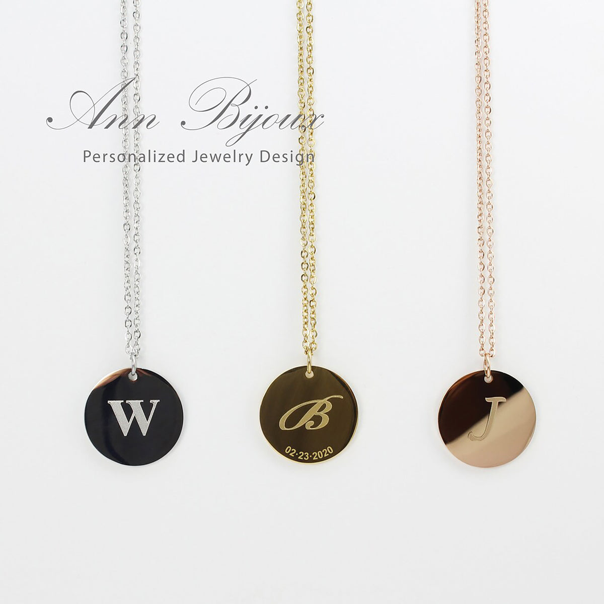 Three necklaces with round pendants displaying letters 'W', 'B', and 'J' on a white background. Brand 'Ann Bijoux' is visible.