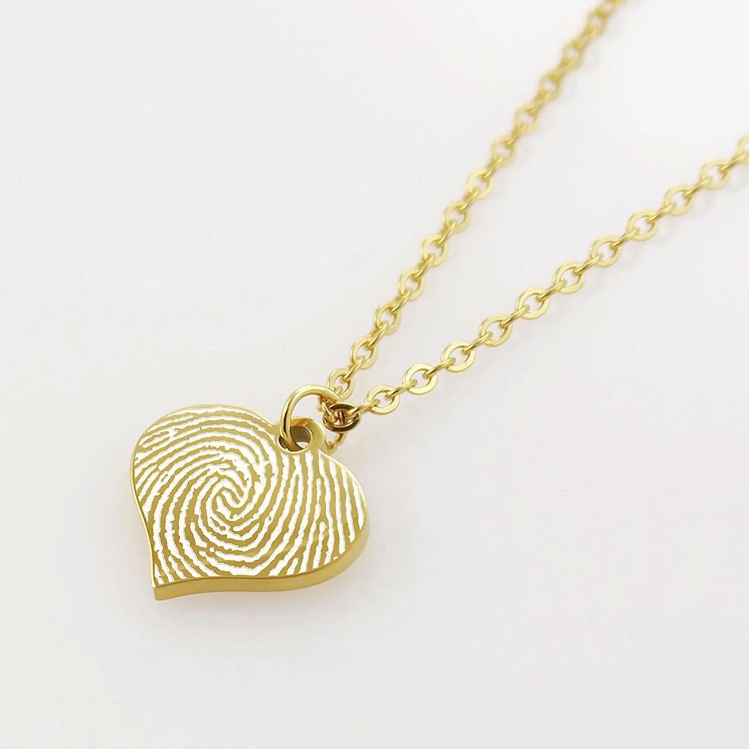 "Gold heart necklace with custom fingerprint engraving on a delicate cable chain."

