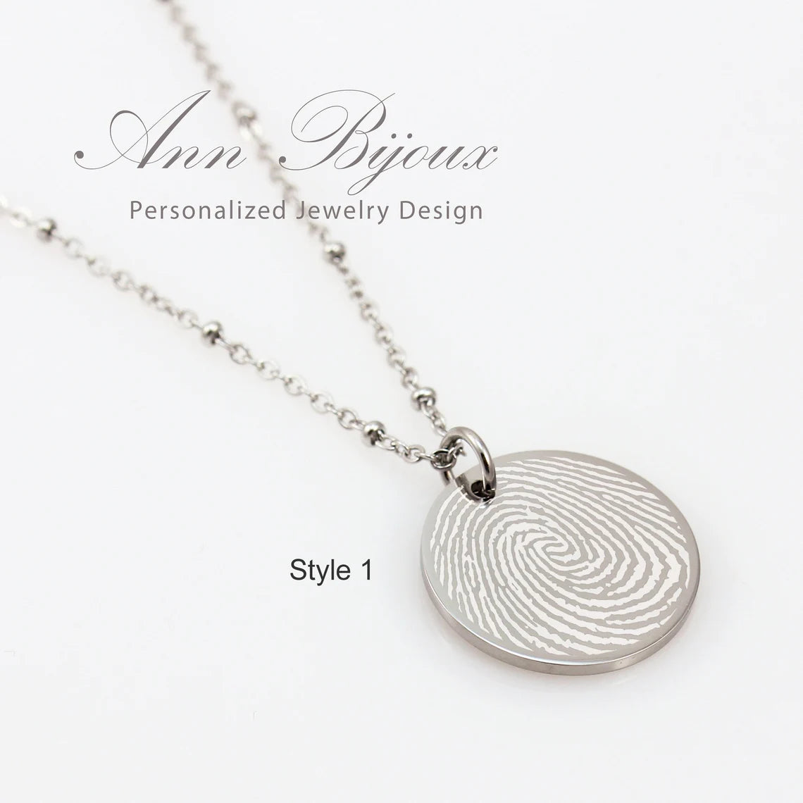 "Personalized silver disc necklace with custom fingerprint engraving on a satellite bead chain."
