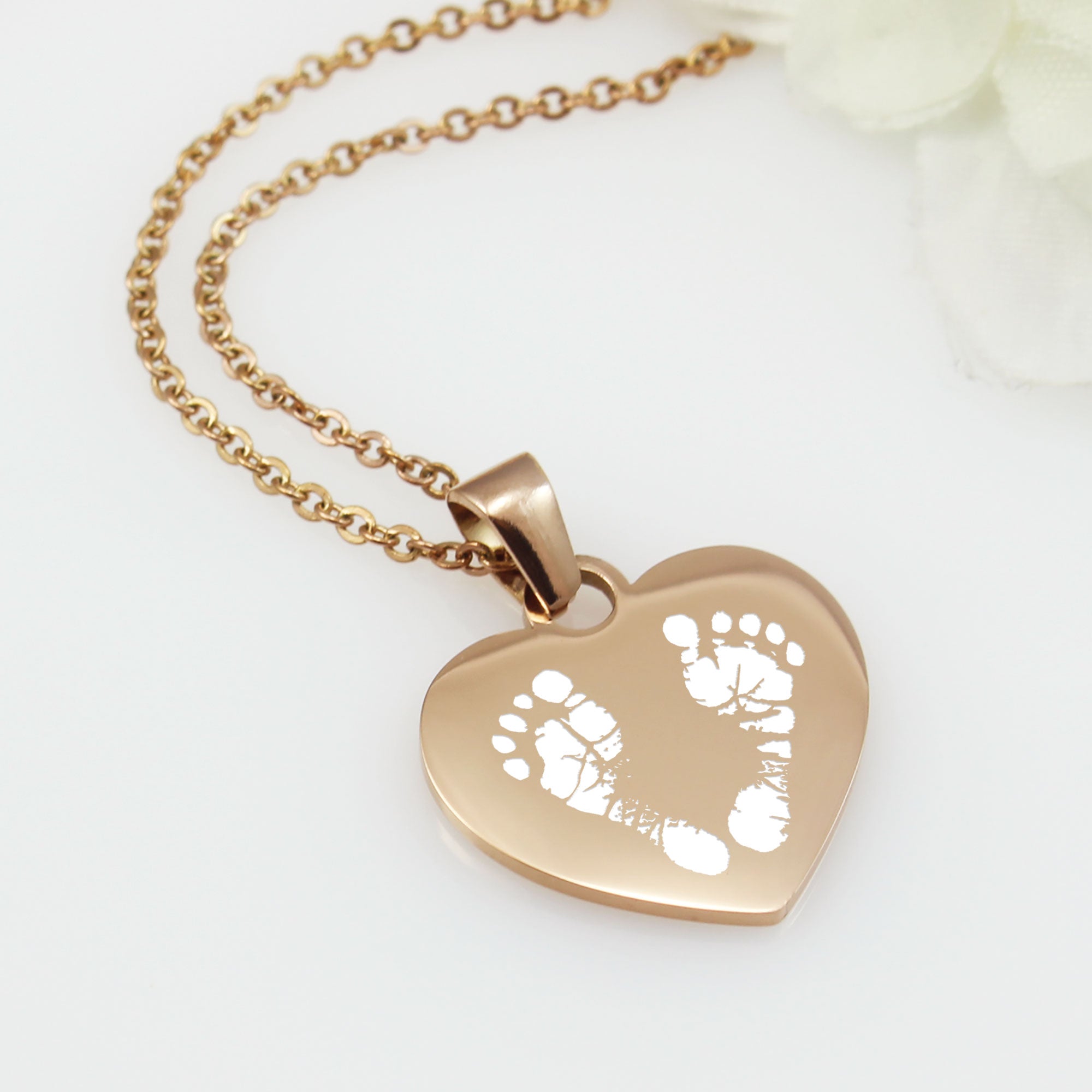 "Personalized silver heart necklace with baby footprint engraving and custom name."