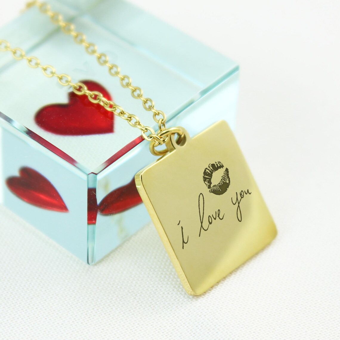 Custom handwriting necklaces in silver, gold, and rose gold square pendants showing the original handwritten notes and their corresponding engravings.