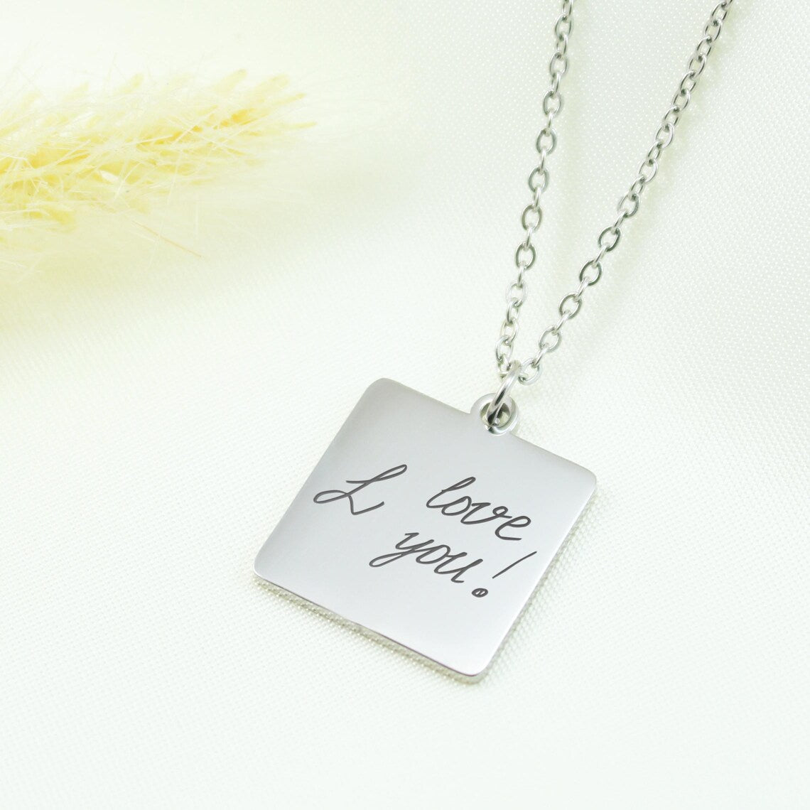 Trio of personalized square pendants engraved with unique handwriting and a lip print, displayed with the original source images below each necklace.