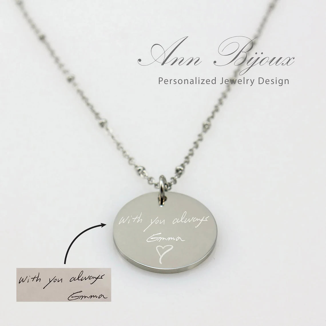 "Personalized silver disc necklace with custom handwriting engraving on a satellite bead chain."