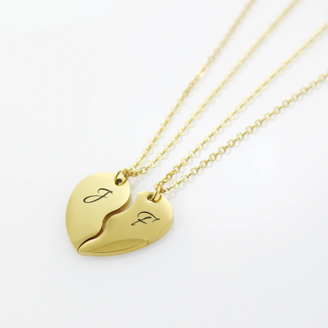Personalized silver break-apart heart necklaces with custom initial engravings for couples or best friends.