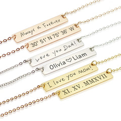 "Six horizontal bar necklaces in gold, silver, and rose gold finishes, showcasing custom engraving options including handwriting, Roman numerals, GPS coordinates, and names with a heart symbol."
