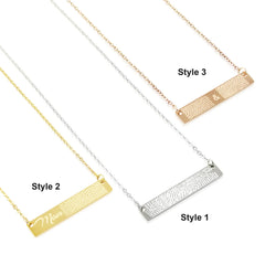 Three stainless steel fingerprint bar necklaces in gold, silver, and rose gold colors, each with a different pattern on the bar pendant.