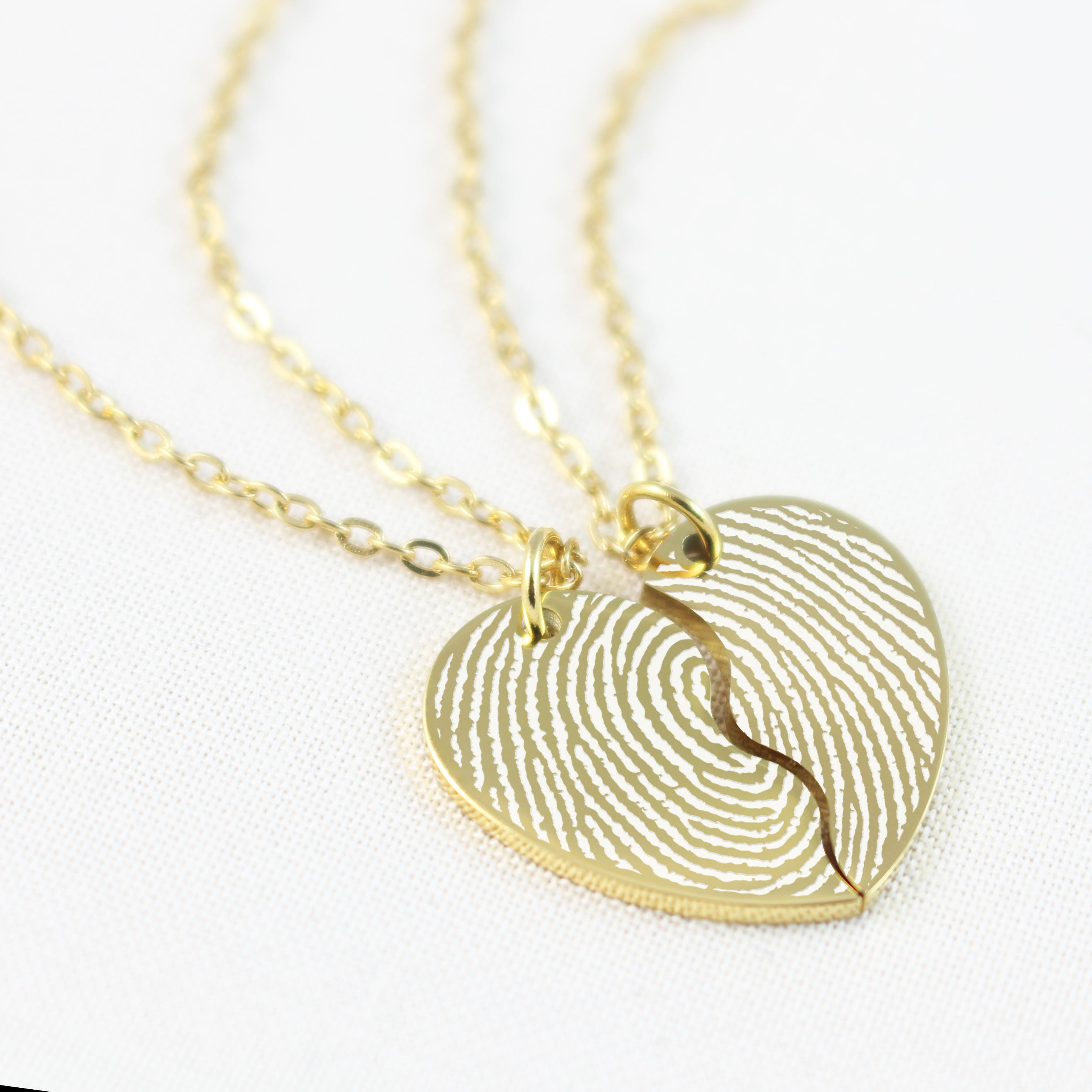 Gold fingerprint heart-shaped pendant necklace on a white background