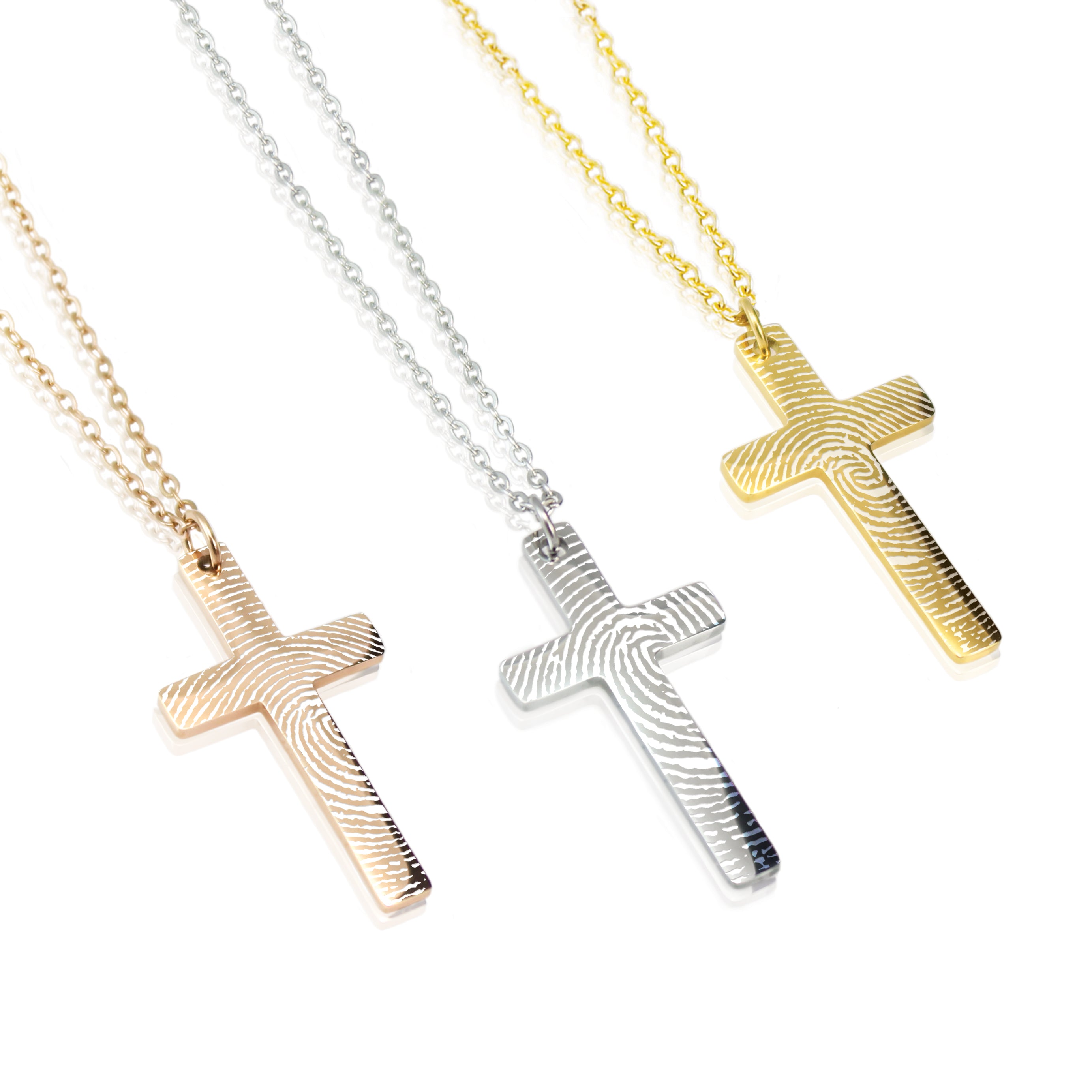 Three cross necklaces in gold, silver, and rose gold on a white background