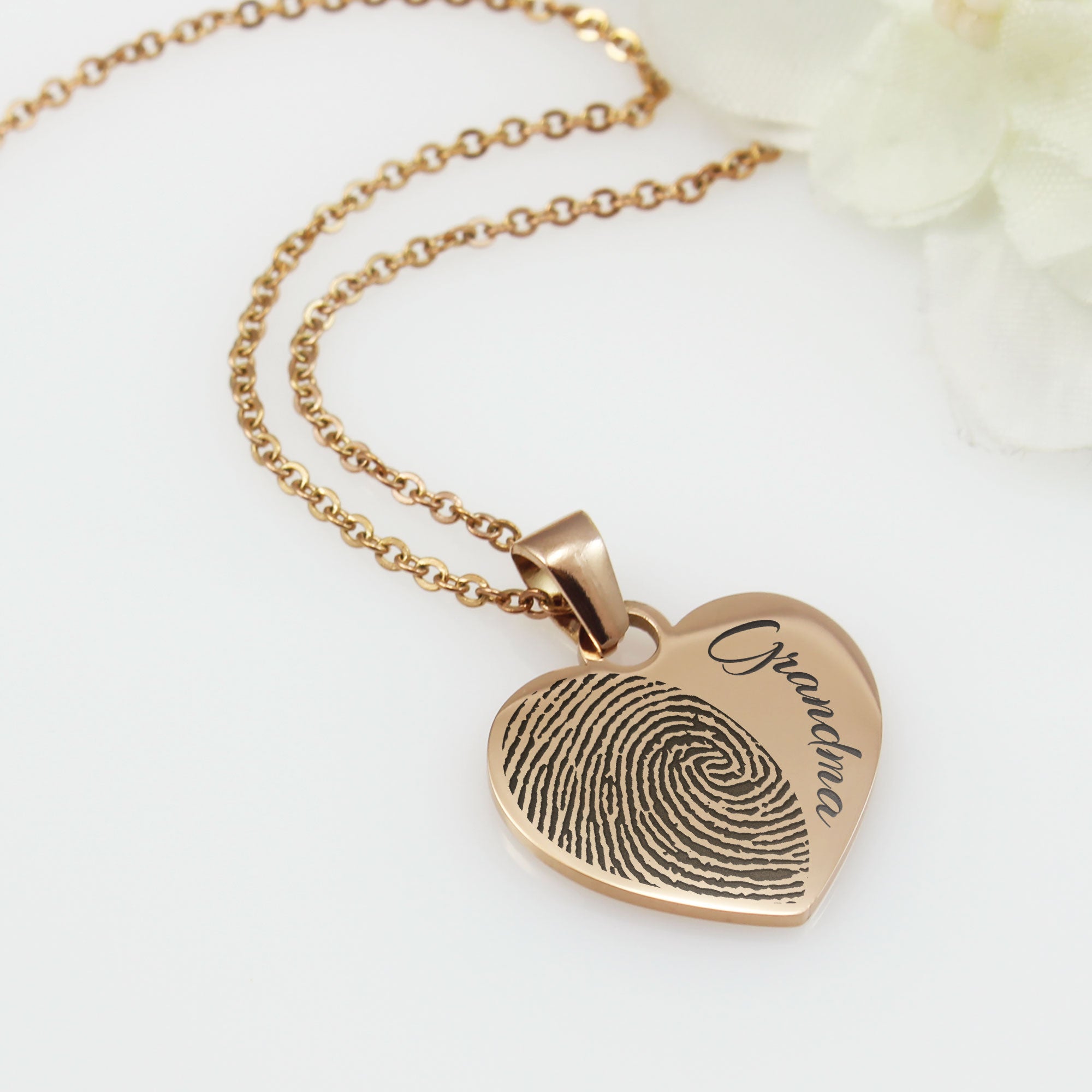 Gold fingerprint heart necklace with 'Grandma' engraving on a white background