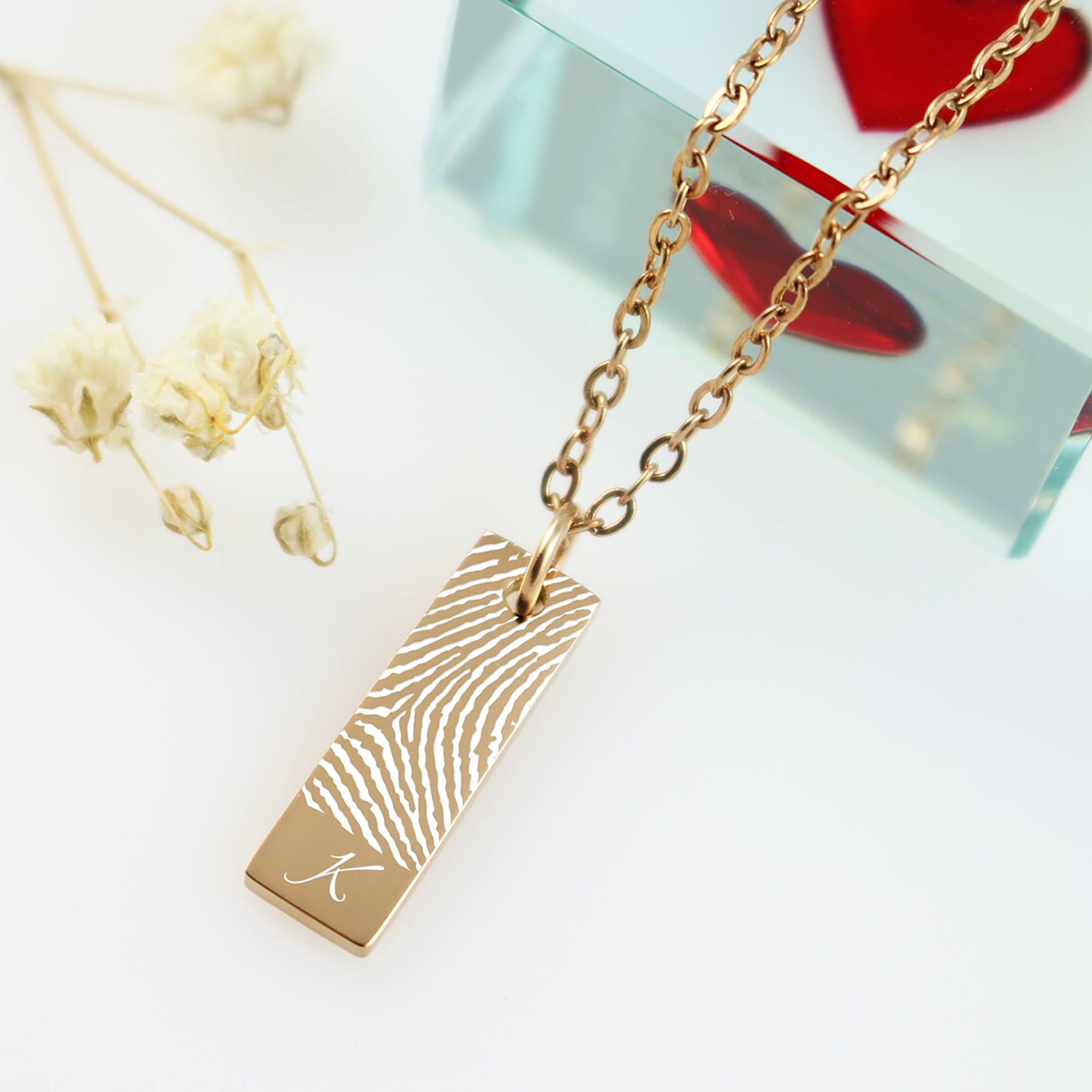 A clean design featuring a fingerprint segment accented by a single, stylish initial at the bottom.