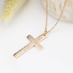 Gold cross necklace on a white background