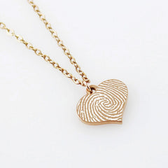 "Personalized fingerprint heart necklace in silver, a unique memorial or sentimental gift featuring the actual thumbprint of a loved one engraved on a heart pendant."