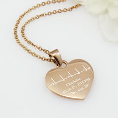 Rose gold heart-shaped necklace with engraved details on a white background