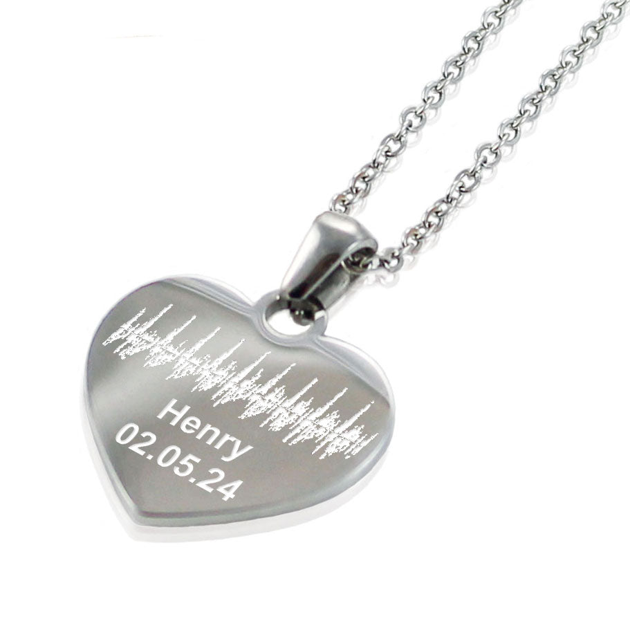 "Silver heart pendant necklace featuring a custom engraved soundwave pattern. The personalized jewelry includes the name 'Henry' and a date '02.05.24' etched below the unique audio wave design."