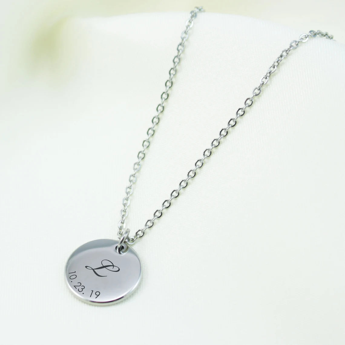 Custom engraved disc necklaces with initials and dates in sterling silver, 14k gold, and rose gold finishes.