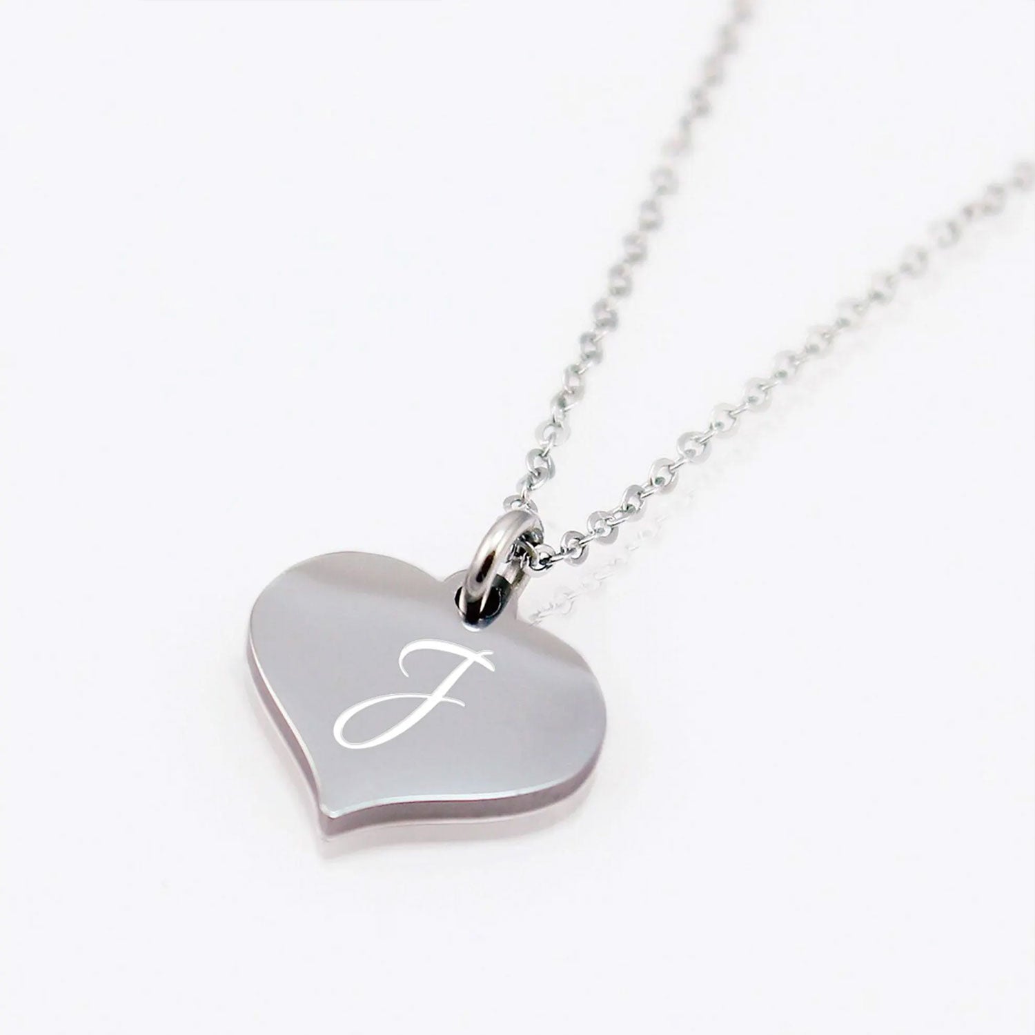 Heart-shaped silver pendant with engraved letter 'F' on a white background