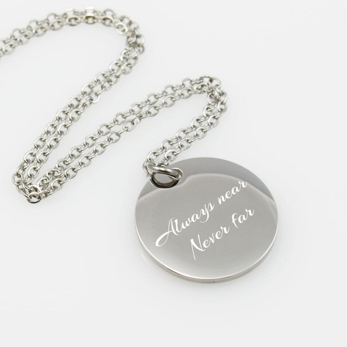 Personalized silver message necklace featuring a round disc engraved, accented by purple and light blue crystal charms.