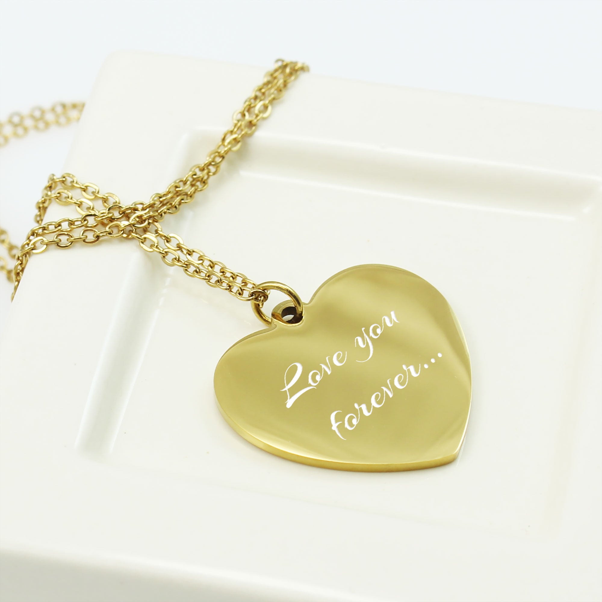 Gold heart-shaped pendant necklace with 'Love you forever' engraving on a white background