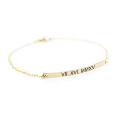 A slender, polished silver horizontal bar engraved with roman number, attached to a thin silver chain against a clean white background.
