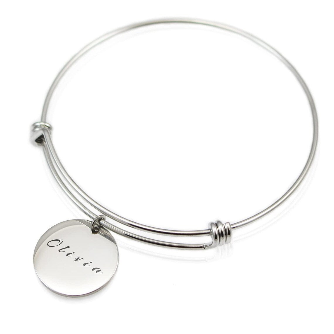 Silver bracelet with a round charm engraved with 'Olivia' on a white background
