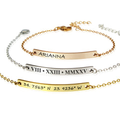 Gold and silver bracelets with engraved text on a white background