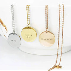 Personalized name necklaces in silver, gold, and rose gold featuring round disc pendants engraved with names Emma, Olivia, and Isabella.