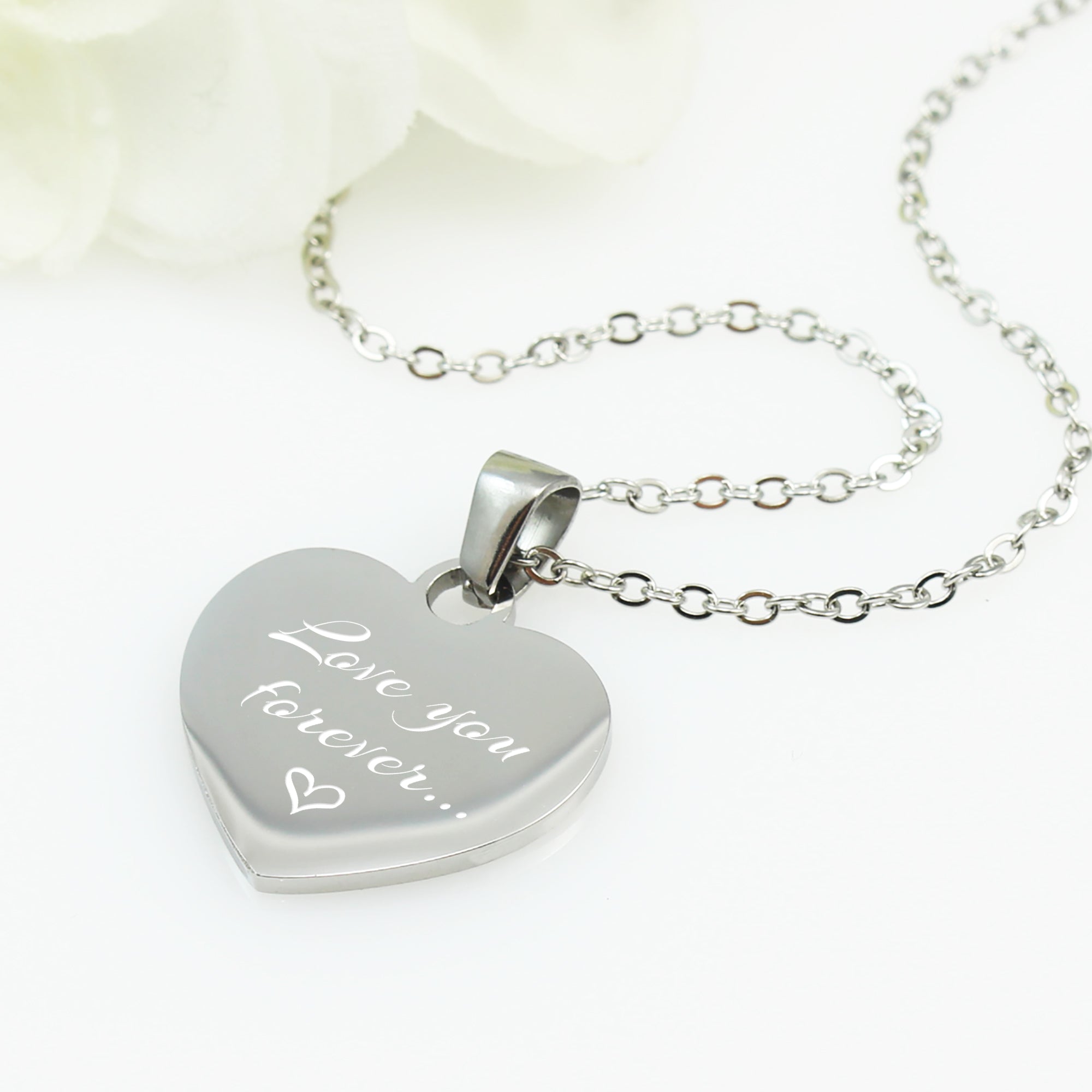 "Personalized heartbeat or soundwave necklace with custom text. A polished silver heart charm engraved with a unique voice recording visualization and a birth date."