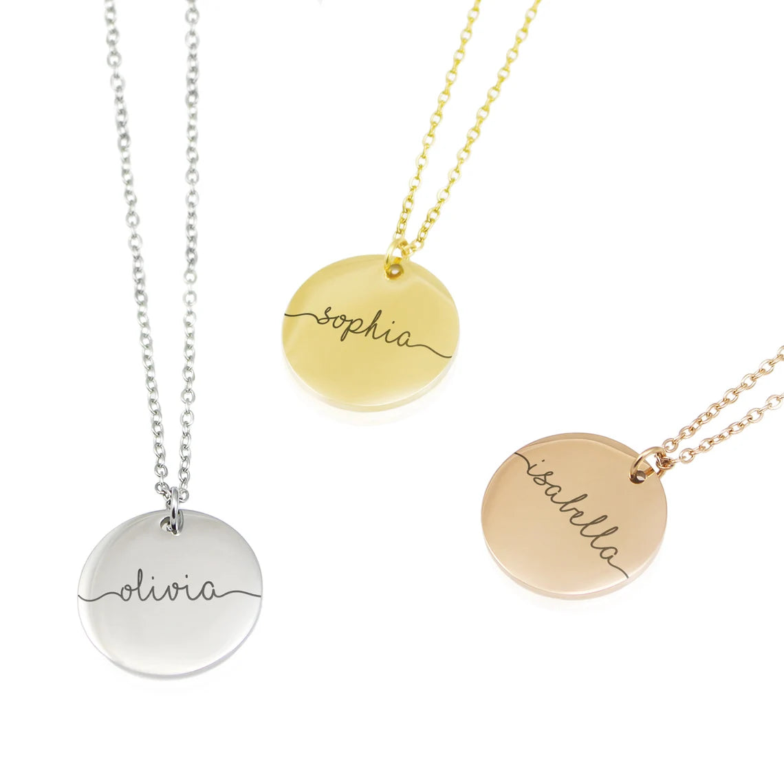 Three round personalized disc necklaces in silver, gold, and rose gold. Each pendant is engraved with a name—Olivia, Sophia, and Isabella—in a flowing, continuous line cursive script that extends to the edges of the disc.