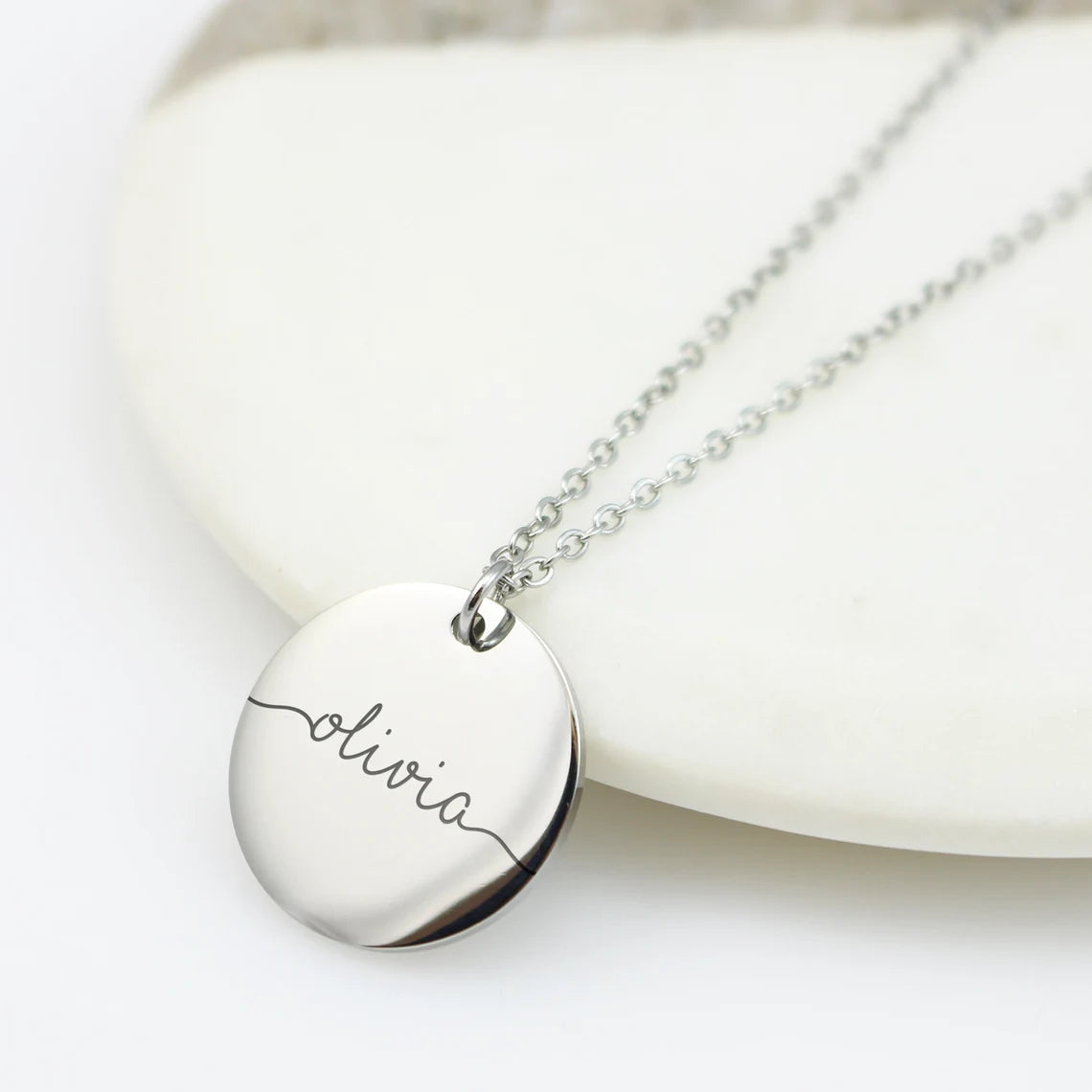 Personalized name disc necklaces in silver, gold, and rose gold with custom cursive signature engravings.
