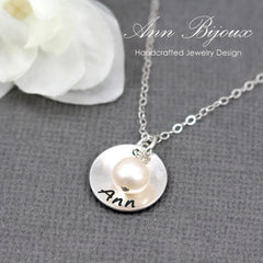 Silver necklace with a round pendant featuring the name 'Ann' on a gray background.