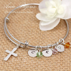 Silver bracelet with charms and beads on a textured surface with 'Ann Bijoux' branding.
