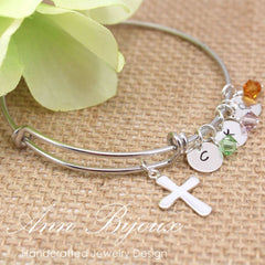 Silver bracelet with charms on a textured surface with flowers