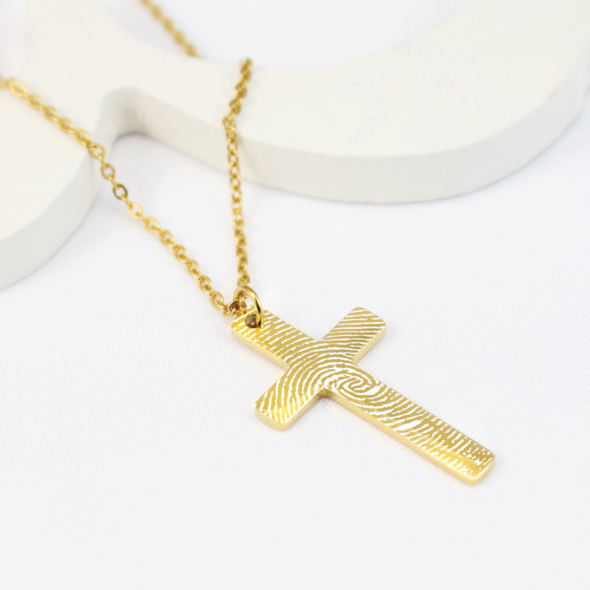 Gold cross necklace on a white background