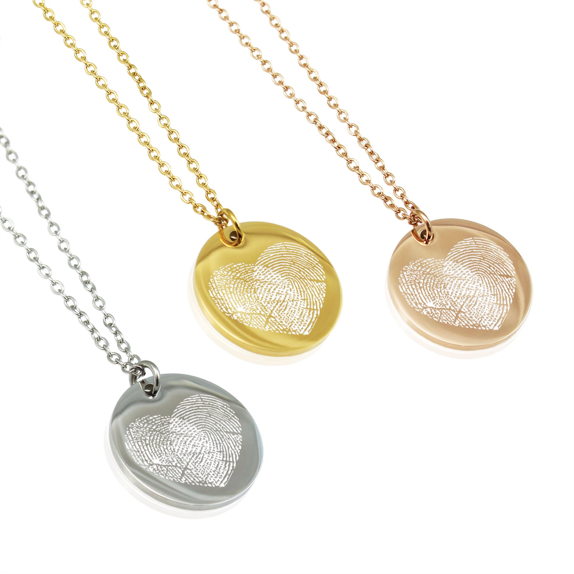 Three heart-shaped fingerprint pendants on gold, rose gold, and silver chains against a white background.
